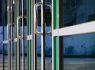 Chrome door handle and glass of modern aluminium door outside the office building